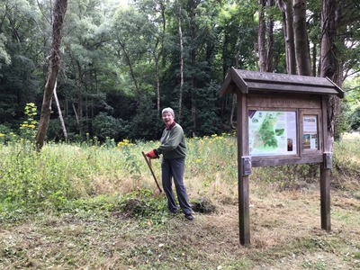 Sue scything at trail entrance